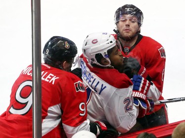 Bobby Ryan, right, and Milan Michalek of the Ottawa Senators hit Devante Smith-Pelly of the Montreal Canadiens during first period action.