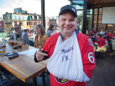 Brian Watters at the Sens House wearing a sling that says "Thanks P.K." as Sens fans pour onto the Sens Mile along Elgin St and the Sens Square in Byward Market to watch Friday's game between Montreal Canadiens and Ottawa Senators being played in Montreal.
