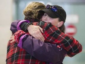 Canadian climbers, left, Matt Carson and Leanne Cusack share a hug after the two arrived hime from Nepal at the Ottawa airport.
