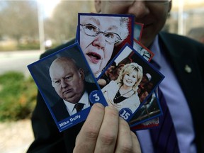 NDP MP Charlie Angus holds up a deck of 'Senate Hall of Shame' collector cards as he visits the Ottawa Courthouse in Ottawa on Monday April, 13, 2015.