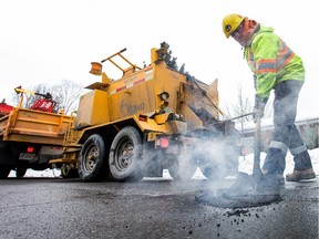 A City of Ottawa road crew fills potholes. The basic infrastructure in cities is in trouble, but a higher sales tax isn't the answer.