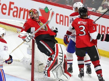 Craig Anderson of the Ottawa Senators falls in his net after Tomas Plekanec of the Montreal Canadiens elbowed him during third period NHL action.