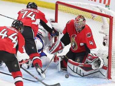 Craig Anderson of the Ottawa Senators makes the save as Mark Borowiecki gets a penalty for hitting David Desharnais of the Montreal Canadiens during first period action.