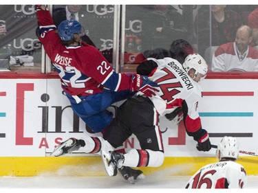 Montreal Canadiens' Dale Weise is checked into the boards by Ottawa Senators' Mark Borowiecki during first period NHL playoff hockey action Wednesday, April 15, 2015 in Montreal.
