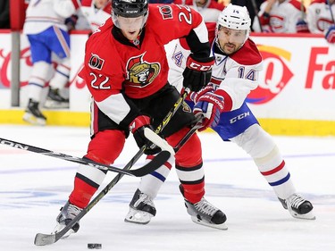 Erik Condra keeps the puck away from Tomas Plekanec in the first period.