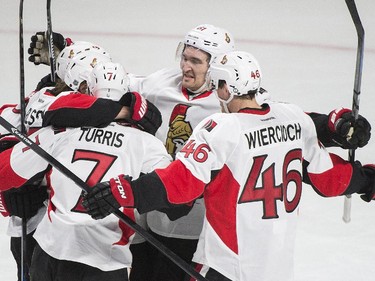 Ottawa Senators' Erik Karlsson, second left, celebrates with teammates after scoring against the Montreal Canadiens during second period of Game 5 NHL first round playoff hockey action in Montreal, Friday, April 24, 2015.