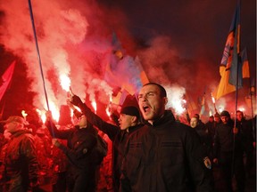 Fighters from the Azov volunteer battalion ignite flares during the march marking the 72th anniversary of the Ukrainian Insurgent Army in Kiev, Ukraine, Tuesday, Oct. 14, 2014. The Ukrainian Insurgent Army initially collaborated with the Nazis, believing Hitler would grant Ukraine independence, but then went on to fight both Nazi forces and the Red Army.