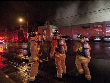 Firefighters attempt to control a structure fire at the Beaver's Mug cafe and Silver Scissors Hair  in the Glebe on Bank Street in Ottawa on Thursday, April 9, 2015.