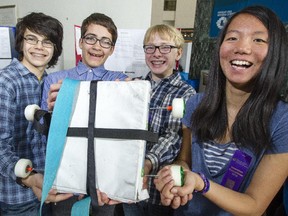 Sam Israelstam (left), Jasper Smith, Henry Morris and JiaQi Han from Fisher Park/Alternative Summit School show off their Binder Board during The Learning Partnership's 2015 Investigate! Invent! Innovate! Invention Convents at Ottawa City Hall on Thursday.