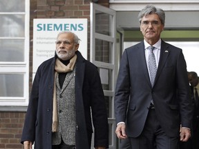 Siemens CEO Joe Kaeser (R) and Indian Prime Minister Narendra Modi leave after a visit to the Siemens company in Berlin, on April 13, 2015.
