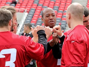 Henry Burris fist bumps his fellow quarterbacks as the Ottawa Redblacks hold a mini camp at TD Place.