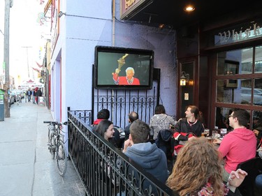 Hockey fans watch an outdoor screen at the Sir John A Pub on the Sensmile on Elgin Street to watch the Ottawa Senators take on the Montreal Canadiens on television in game 1 of the playoffs.