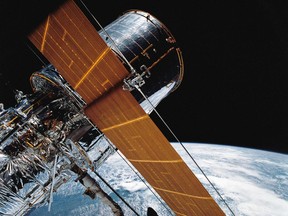 In this April 25, 1990 photograph provided by NASA, part of the giant Hubble Space Telescope can be seen as it is suspended in space by Discovery's Remote Manipulator System (RMS) following the deployment of part of its solar panels and antennae. This was among the first photos NASA released on April 30 from the five-day STS-31 mission.