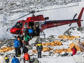 In this Sunday April 26, 2015, photo provided by 6summitschallenge.com, a helicopter prepares to rescue people at Everest Base Camp, Nepal.