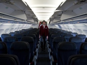 Flight attendant Jason Morales prepares an Air Canada Rouge Airbus A319 for a flight to Las Vegas at Vancouver International Airport in Richmond, B.C., on Monday, April 28, 2014.
