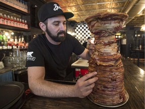 Jean-François Leduc touches up his reproduction of the Stanley Cup made with 10 kilograms of bacon in Montreal.