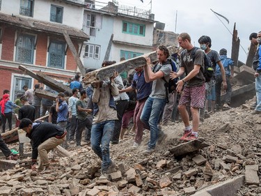 KATHMANDU, NEPAL - APRIL 25: Emergency workers and bystanders clear debris while searching for survivors under a collapsed temple in Basantapur Durbar Square following an earthquake on April 25, 2015 in Kathmandu, Nepal. A major 7.8 earthquake hit Kathmandu mid-day on Saturday, and was followed by multiple aftershocks that triggered avalanches on Mt. Everest that buried mountain climbers in their base camps. Many houses, buildings and temples in the capital were destroyed during the earthquake, leaving hundreds dead or trapped under the debris as emergency rescue workers attempt to clear debris and find survivors.