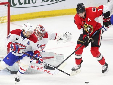 Kyle Turris of the Ottawa Senators tries to get the puck from Carey Price of the Montreal Canadiens as Tomas Plekanec looks on during first period action.