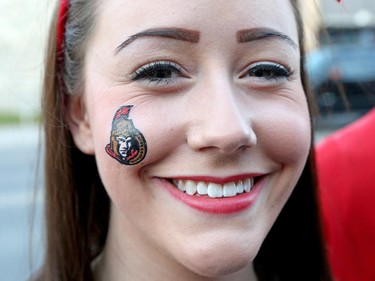 Laura Rainville wears a Sens sticker on her cheek as hockey fans head to the Sensmile on Elgin Street to watch the Ottawa Senators take on the Montreal Canadiens on television in game 1 of the playoffs.