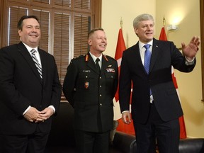 Lt.-Gen. Jonathan Vance, centre, poses for a photo in Ottawa on Monday, April 27, 2015 with Defence Minister Jason Kenney, left, and Prime Minister Stephen Harper after Vance was appointed the next chief of defence staff.