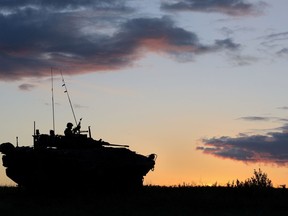 The crew commander of a Canadian Forces Light Armoured Vehicle surveys the simulated battlefield as the sun begins to rise on the final day of Exercise MAPLE RESOLVE at Canadian Forces Base Wainwright on 31 May 2014. Photo: Sgt Matthew McGregor, Canadian Forces Combat Camera.