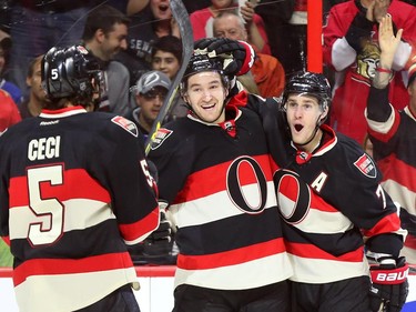 Mark Stone celebrates his 20th goal of the season with Cody Ceci, left, and Kyle Turris, right, during first period NHL action.