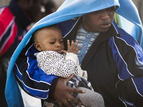 A migrant woman and a young child board a ship bound for Sicily on April 23, 2015 in Lampedusa, Italy. It is expected that EU leaders in Brussels are to agree later that only 5,000 resettlement places across Europe are to be offered to refugees under a new emergency summit crisis package. Hundreds of migrants continue to arrive in Lampedusa from North Africa taking advantage of calm seas. Hundreds of migrants are believed to have perished over the last week as they attempted to cross the Mediterranean from Libya to Italy in order to seek refuge.