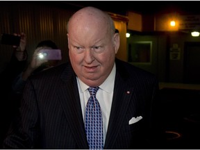 Media surround Mike Duffy as he leaves Parliament  on Oct. 22, 2013.