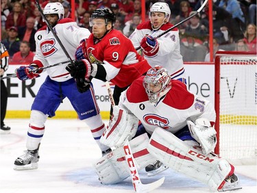 Milan Michalek is sandwiched between P.K. Subban (L) and goalie Carey Price (R) in the third period as the Montreal Canadiens and the Ottawa Senators play game 3 of the first round playoffs at Canadian Tire Centre.