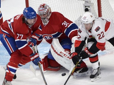 Montreal Canadiens goalie Carey Price watches the puck as Ottawa Senators' Erik Condra (22) and Canadiens' Tom Gilbert (77) battle in front of the net during first period NHL playoff action in Montreal, Wednesday, April 15, 2015.