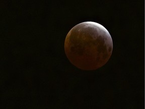 A lunar eclipse is observed as seen from Echo Park district of Los Angeles on Saturday, April 4, 2015.  Early risers in the western U.S. and Canada were treated to the spectacle before dawn Saturday. The moment when the moon was completely obscured by Earth's shadow lasted several minutes, making it the shortest lunar eclipse of the century.