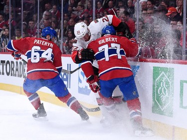 Erik Condra #22 of the Ottawa Senators, and Tom Gilbert #77 of the Montreal Canadiens chase the puck into the boards during Game Five of the Eastern Conference Quarterfinals of the 2015 NHL Stanley Cup Playoffs at the Bell Centre on April 24, 2015 in Montreal, Quebec, Canada.