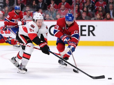 Mark Stone #61 of the Ottawa Senators attempts to move the puck past Alex Galchenyuk #27 and Andrei Markov #79 of the Montreal Canadiens in Game Two of the Eastern Conference Quarterfinals during the 2015 NHL Stanley Cup Playoffs at the Bell Centre on April 17, 2015 in Montreal, Quebec, Canada.