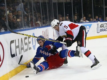Kevin Hayes #13 of the New York Rangers is taken down by Cody Ceci #5 of the Ottawa Senators during the second period.