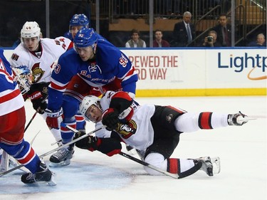 Curtis Lazar #27 of the Ottawa Senators gets the shot off during the third period as he is checked by Keith Yandle #93 of the New York Rangers during the third period.