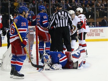 Henrik Lundqvist #30 of the New York Rangers shows the effects of being interferered with by Mika Zibanejad #93 of the Ottawa Senators during the first period.