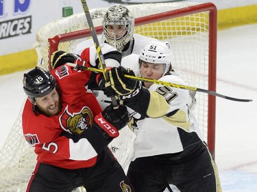 Pittsburgh Penguins' Derrick Pouliot (51) battles Ottawa Senators' Zack Smith (15) in front of Penguins goalie Marc-Andre Fleury during first period NHL action.