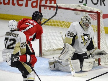 Pittsburgh Penguins goaltender Marc-Andre Fleury (29) makes a glove save as teammate Patric Hornqvist (72) marks Ottawa Senators' Kyle Turris (7) second period NHL action.