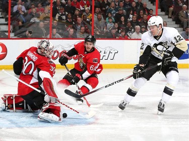Andrew Hammond #30 of the Ottawa Senators makes a save on a breakaway by Ben Lovejoy #12 of the Pittsburgh Penguins as Mike Hoffman #68 backchecks on the play.