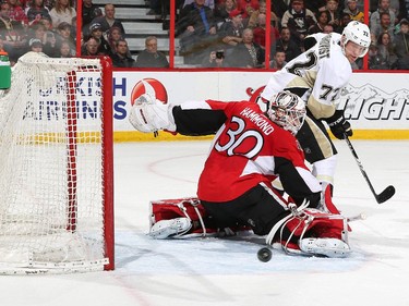Aaron Johnson #72 of the Ottawa Senators makes a save as Patric Hornqvist #72 of the Pittsburgh Penguins looks to make a play on the rebound.