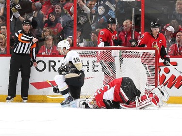 Andrew Hammond #30 of the Ottawa Senators lies face down in his crease after colliding with Brandon Sutter #16 of the Pittsburgh Penguins as referee Chris Rooney signals a goal. Bobby Ryan #6 and Erik Karlsson #65 of the Ottawa Senators look on.