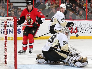 Marc-Andre Fleury #29 of the Pittsburgh Penguins makes a save as teammate Nick Spaling #13 looks on with Mika Zibanejad #93 of the Ottawa Senators.