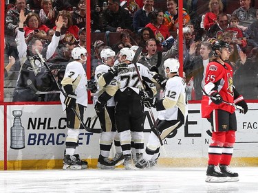 Sidney Crosby #87 of the Pittsburgh Penguins celebrates his first period goal with teammates Paul Martin #7, Patric Hornqvist #72 and Ben Lovejoy #12 as Erik Karlsson #65 of the Ottawa Senators looks away.