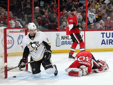 Andrew Hammond #30 of the Ottawa Senators lies on the ice after allowing the second goal of the first period as Brandon Sutter #16 of the Pittsburgh Penguins looks on.
