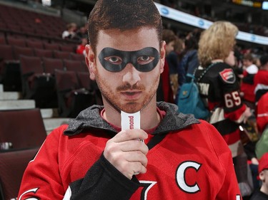 A fan holds up a face-mask of Andrew Hammond prior to the start of the game.