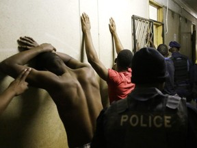 Police officers search people during their raid at a hostel in Alexandra township, Johannesburg, South Africa, Thursday, April 23, 2015. Police and soldiers raided a hostel considered a hotspot for anti-immigrant attacks as South Africa continued a crackdown on anti-immigrant violence.