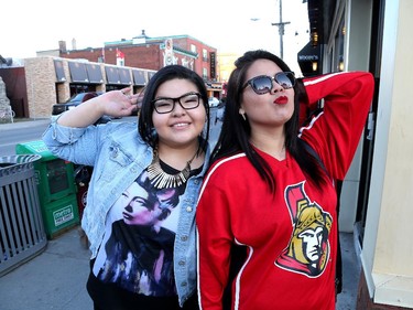 Pupun Penashue (L) and Winter Doxtator are out having fun as hockey fans head to the Sensmile on Elgin Street to watch the Ottawa Senators take on the Montreal Canadiens on television in game 1 of the playoffs.