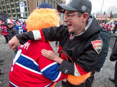 Senators fan Hugo Lamarche gets tackled by Youppie at FanJam 2015 as the Ottawa Senators get set to take on the Montreal Canadiens at the Bell Centre in Montreal for Game 5 of the NHL Conference playoffs on Friday evening.