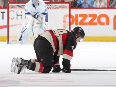 Jean-Gabriel Pageau #44 of the Ottawa Senators is down on the ice after taking a knee-on-knee hit.
