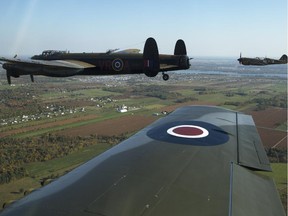 The Canadian Warplane Museum's Avro Lancaster bomber is escorted back to Vintage Wings of Canada at the Gatineau Airport Saturday, September 27, 2014, making a brief stop on its way back from a remarkable summer tour in the U.K. The planes was escorted by Michael Potter flying a P-51 Mustang and Rob Erdos piloting a P-40 Kittyhawk. (Darren Brown/Ottawa Citizen)  assignment: 118482
